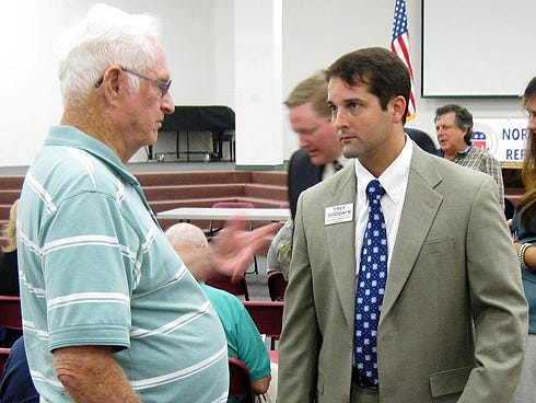 Baker resident Kendall Helms, left, speaks with county commissioner candidate Trey Goodwin during the meet-and-greet prior to Wednesday evening’s candidates’ forum.