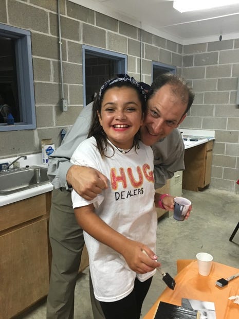 One of the Crestview group's "hug dealers" gets a hug during the Church of Jesus Christ of Latter-day Saints' Girls Camp. (Special to the News Bulletin)