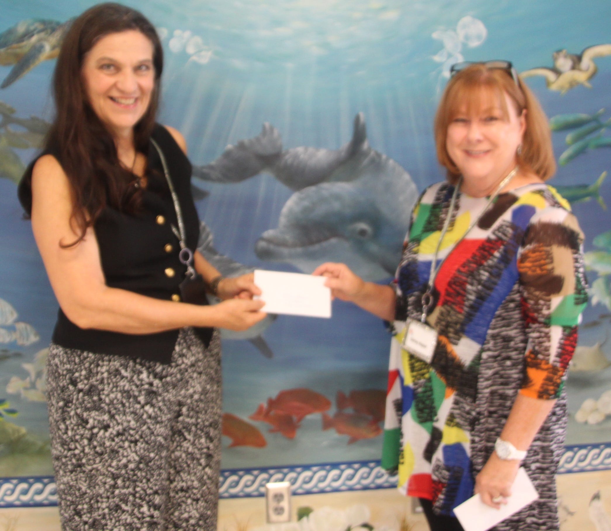 Elia Saxer receives the first-place prize from Okaloosa Public Arts Event Chairperson Shirley Napier. (Special to the News Bulletin)