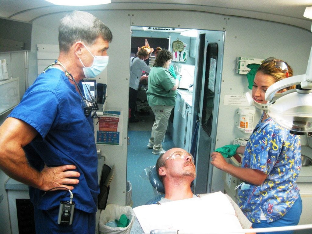 Volunteer dentist Dr. Erik Meyers and his dental assistant, Nicole Vickers, prepare to treat resident Nathan Merritt aboard the Florida Baptist Convention's Mobile Dental Care clinic.