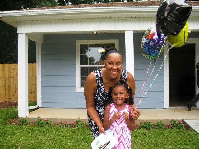 La’Terica Clark and her daughter, Nylah, 4, smile outside their new Crestview home. The house was the fourth local Habitat for Humanity dedicated in less than seven months.