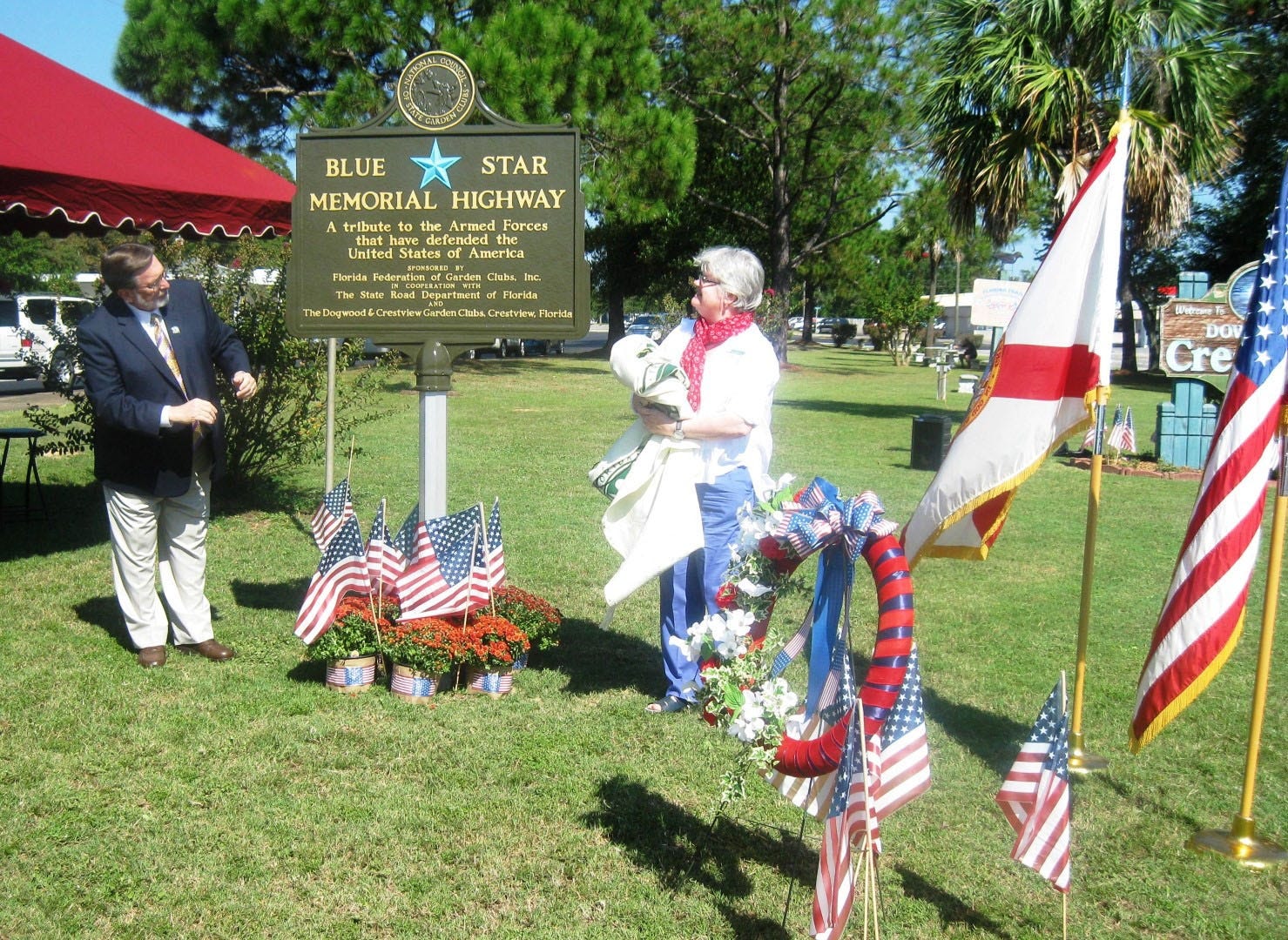 Mayor David Cadle and Dogwood Garden Club President Jane McCreary unveil Crestviewís new Blue Star Memorial Highway marker in Garden Park. (BRIAN HUGHES | News Bulletin)