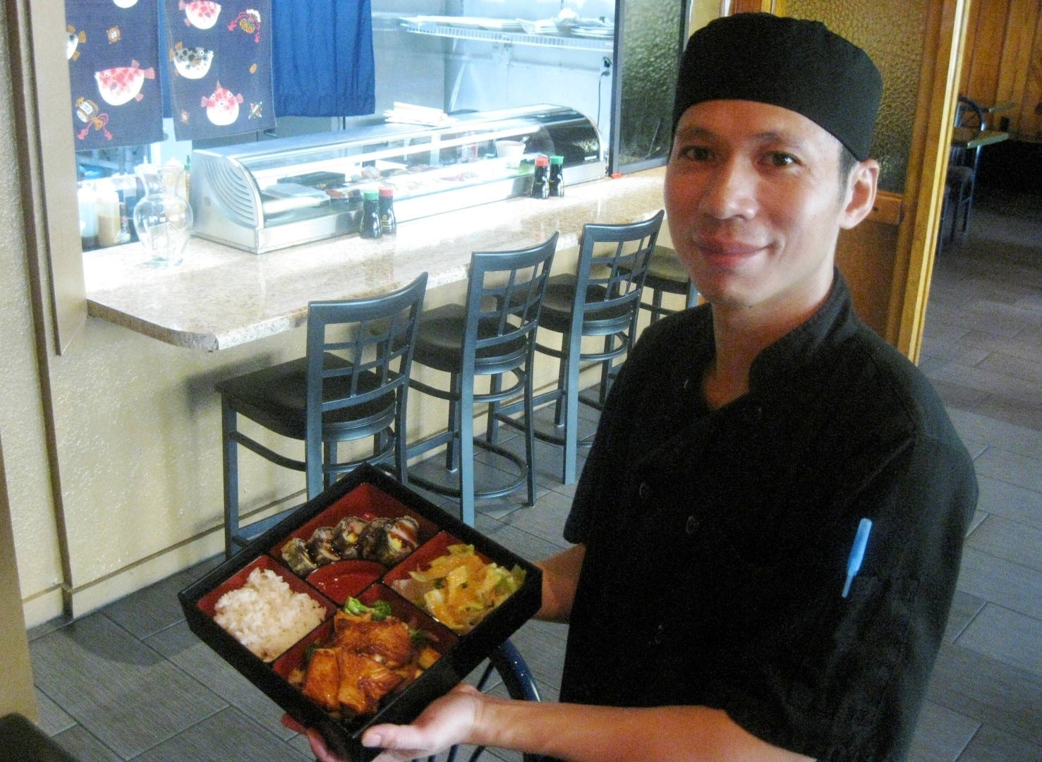 You Sushi and Hibachi owner Jimmy Ye displays an $8.95 lunch box selection, including rice, sushi roll, teriyaki salmon and salad. The lunch also includes miso soup. (BRIAN HUGHES | News Bulletin)