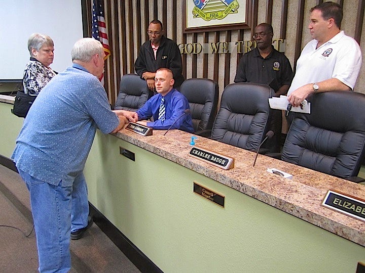 Resident Landrum Edwards, left, discusses the results of a Crestview City Council workshop to discuss the proposed city charter. Councilmen from left are Tim Grandberry, council President Ben Iannucci III, Charles Baugh Jr. and Tom Gordon.