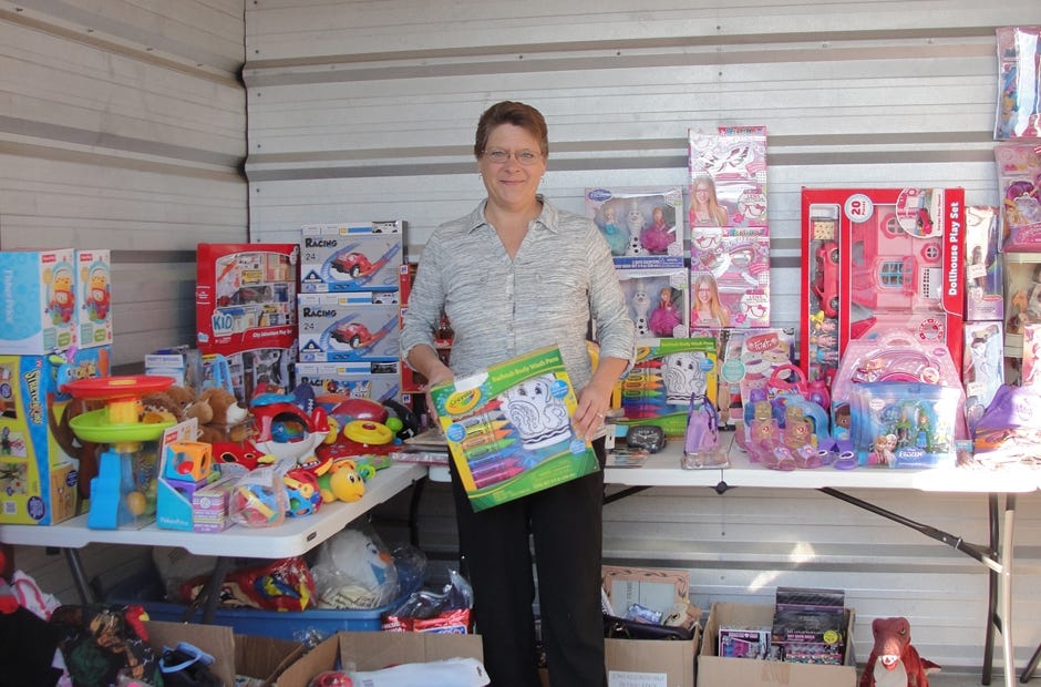 Renee Wiley of Baker stands with several gifts donated for area families who need assistance at Christmas. Samantha Lambert | News Bulletin