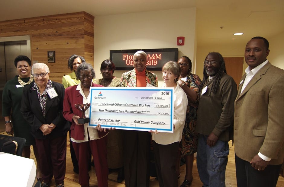 Members of the non-profit organization Concerned Citizens Outreach Workers accept an award of $2,500 from Bentina Terry, Gulf Power vice president of customer services and sales, left, and Bernard Johnson, right, Central District gel manager, during the Power of Service Awards Nov. 15 in Crestview. Special to the News Bulletin