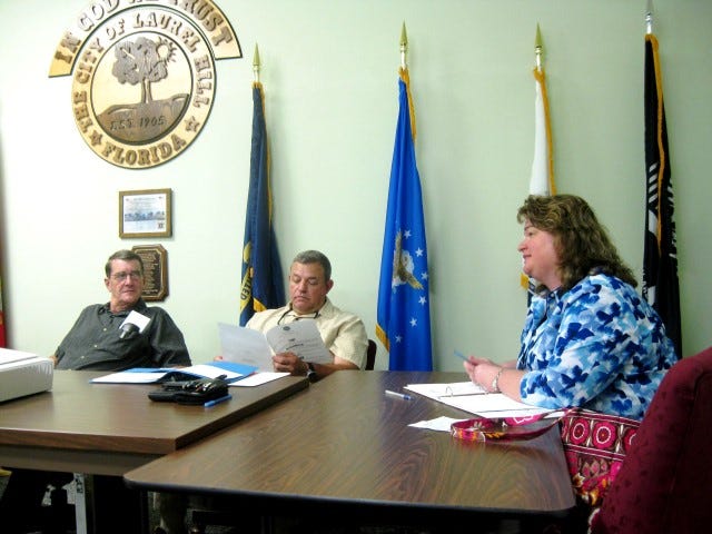 Laurel Hill City Council Chairman Larry Hendren and Councilman Scott Moneypenny listen as Councilwoman Debra Adams offers a suggestion to distribute official city information through monthly water bills.