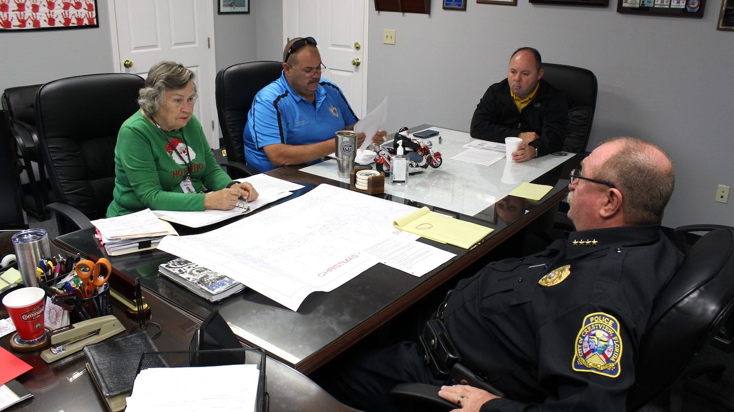 Main Street Crestview Association Director Patti Gonzo discusses Crestview Centennial Christmas Parade safety and organization with Police Chief Tony Taylor, right, Sgt. Mike Leadmon and Cmdr. Jamie Grant. BRIAN HUGHES | Crestview Police Department