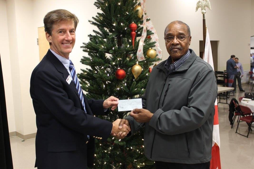 Craig Shaw, the Crestview Area Chamber of Commerce’s treasurer, presents a $2,500 check to Dwight Baggett, of Macedonia Missionary Baptist Church, during the chamber’s Dec. 1 breakfast meeting. (Special to the News Bulletin)