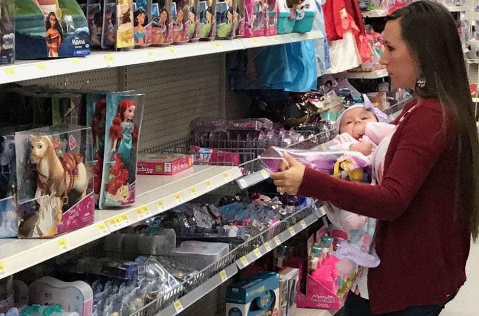 Volunteer Katie Williams decides between toys. MARK JUDSON | News Bulletin