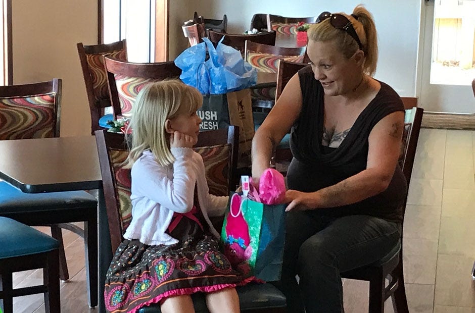 Lilly Ford (left) opens a present with the help of her mother, Susan Ford, Thursday at Comfort Inn and Suites in Crestview. MARK JUDSON | News Bulletin