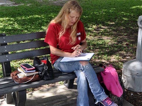 Former Crestview resident Tina Gough writes a letter to Judge Michael A. Flowers this morning while sitting outside the Okaloosa County Courthouse. Since Monday, Gough has protested her husband, Richard's, five-year probation sentence for domestic violence.