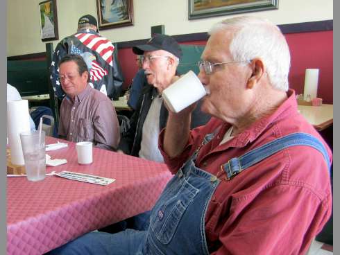 Carl Gay, co-founder of the monthly Duke Field veterans' breakfasts, sips his coffee as George Kilcrease, left, and Gene Rein swap stories.