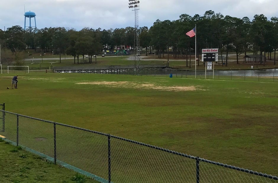 A man plays football with a child at Twin Hills Park in Crestview. Some residents say the park needs improvements and more parks should be built. MARK JUDSON/NEWS BULLETIN