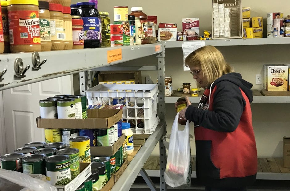 Sharing and Caring's former preseident, Robin Marston, prepares a food donation order for a family in need. MARK JUDSON | News Bulletin
