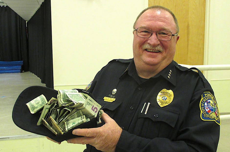 Crestview Police Chief Tony Taylor holds up his cap, which is overflowing with $444.09 in donations to Concerns Of Police Survivors following his address during the Jan. 6 Gordon Martial Arts promotions ceremony. Brian Hughes | Crestview Police Department