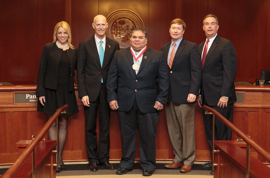 Chained Concepts owner and veteran Mike Davila of Crestview, center, stands with Florida government officials after accepting the Governor's Business Ambassador Award. From left are Attorney General Pam Bondi, Governor Rick Scott, Davila, Agricultural Commissioner Adam Putnam and Chief Financial Officer Jeff Atwater. Special to the News Bulletin