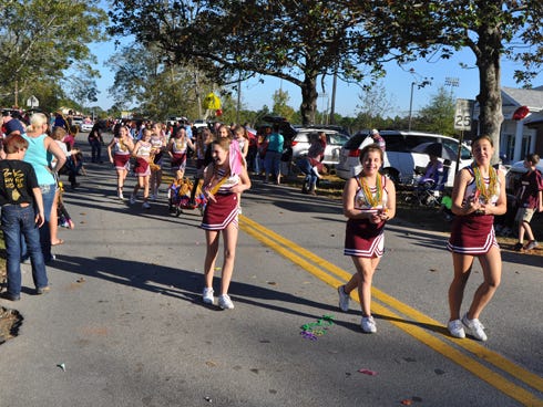 Baker School cheerleaders walk along 14th Street while participating in the school’s annual homecoming parade on Friday afternoon.