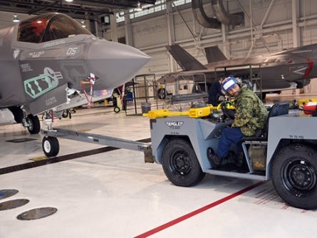 F-35B maintainer Antonio Spencer moves an F-35B in a hangar at Eglin Air Force Base on Tuesday. Maintainers for Lockheed Martin and the Marines will continue to work and train on the 13 F-35Bs at the base until flights are given the OK to resume.