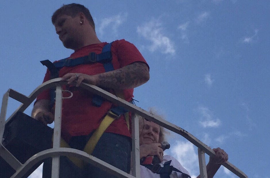 Lana Caputo holds her pet parrot, Zazoo, after she and Brandon Severns of Signs Galore, Inc. rescued the bird using the SGI bucket truck. "It was something new, something different," Severns said of the rescue. [Tiffani Ridenour | Special to the News Bulletin]
