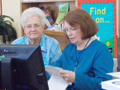 Laurel Hill Mayor Joan Smith, left, receives tax preparation assistance from AARP tax aide Pat Hagan at the Crestview Public Library.