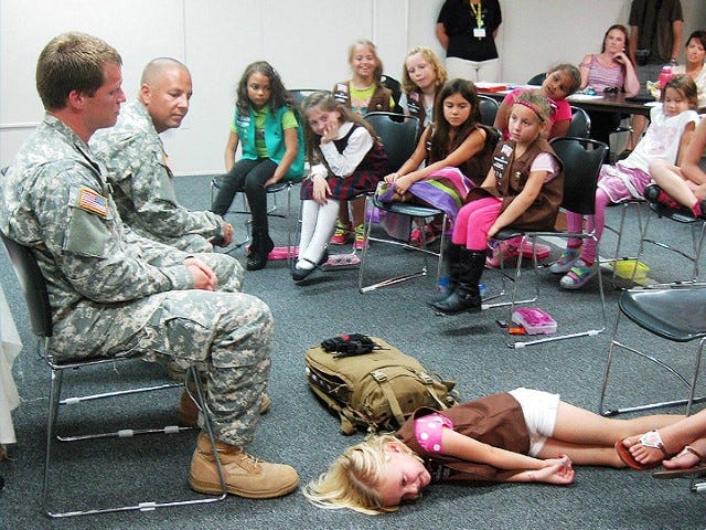 Under Sgts, Matthew Roper and Fred Gonzalez’s instruction, Brownie Skylar Calhoun demonstrates the position of an injury or shock victim after a first responder has done a preliminary examination.