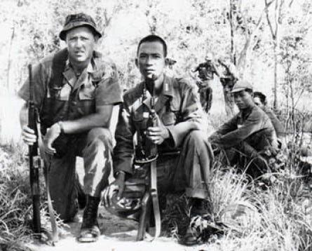 Johnnie Prichard, left, and other members of his unit stop for a trailside meal, which typically included monkey and lizard.