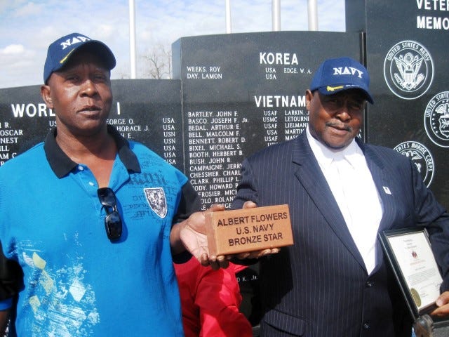 Brothers Kent and Albert Flowers Jr. display the memorial brick honoring their father, Albert Flowers Sr., before it was laid Feb. 21 at the Okaloosa County Veterans Memorial.
