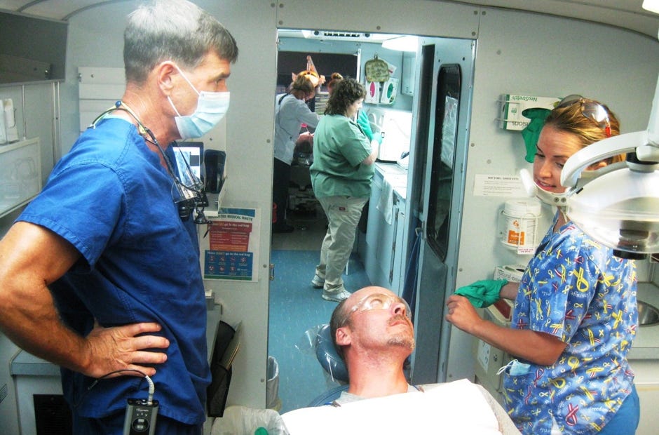 Volunteer dentist Dr. Erik Meyers and his dental assistant, Nicole Vickers, prepare to treat resident Nathan Merritt aboard the Florida Baptist Convention's Mobile Dental Care clinic May 2016 in Baker. [File Photo | News Bulletin]