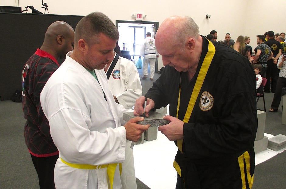 Crestview taekwondo student Chris Crawford gets his concrete block autographed by guest Grand Master Rudy Timmerman during the Crestview Korean Martial Arts Festival. [Brian Hughes | Special to the News Bulletin]