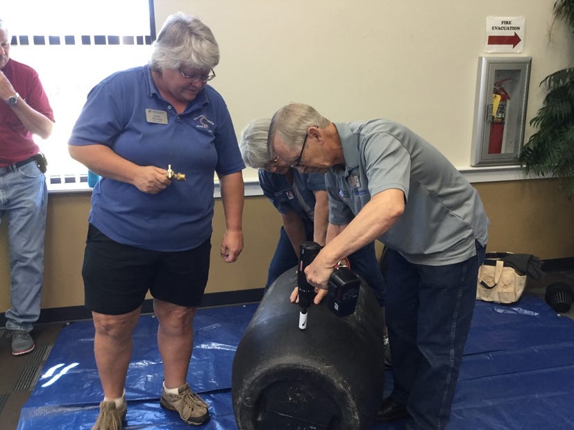 Sheila Dunning and Master Gardeners Ed and Lynn Fabian demonstrate how to make a rain barrel May 2 at the Crestview Public Library. [CPL | Special to the News Bulletin]