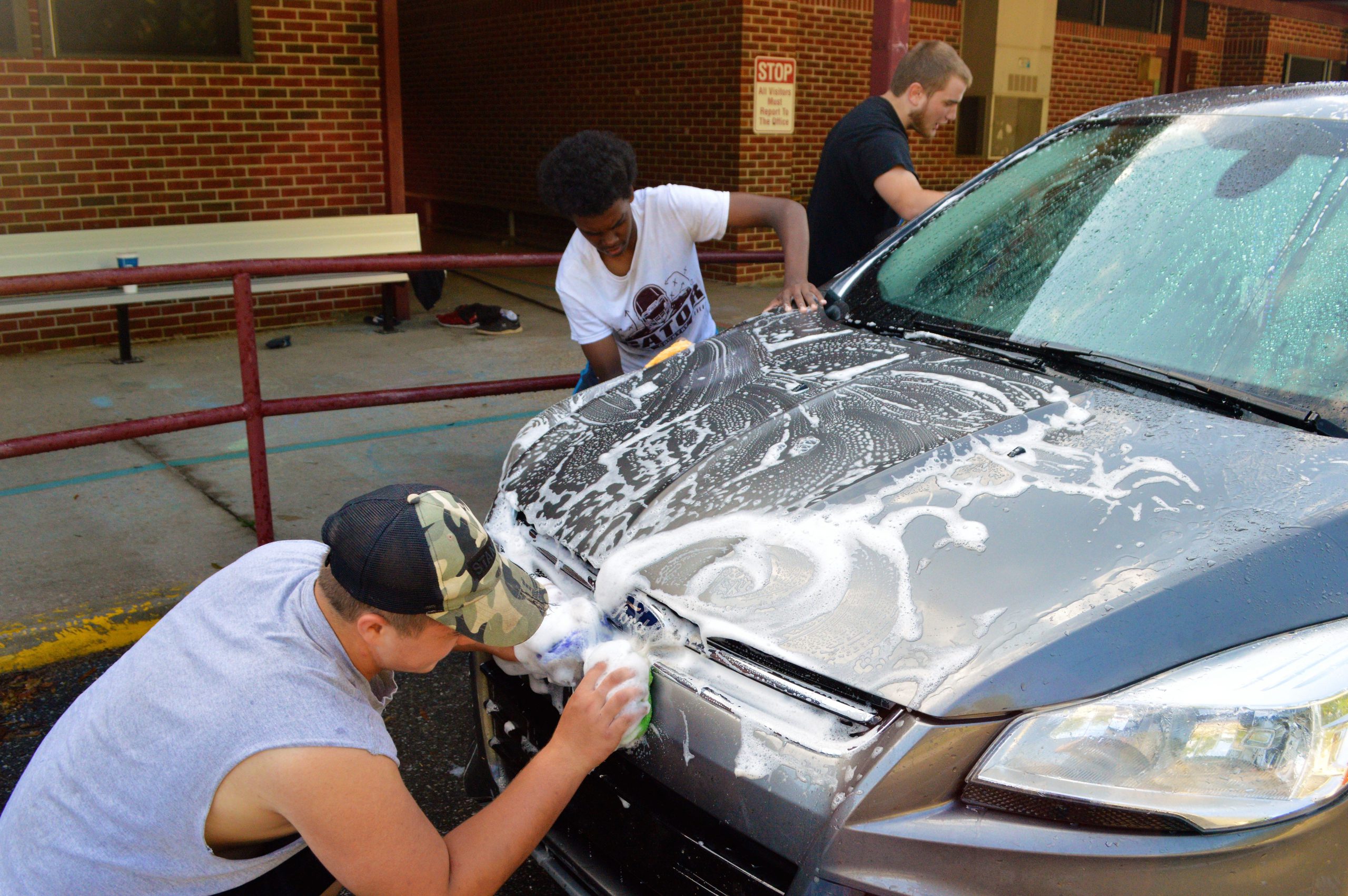Baker football players scrub down vehicles at no charge while patrons enjoy a pancake breakfast. [JOHNNY C. ALEXANDER | News Bulletin]