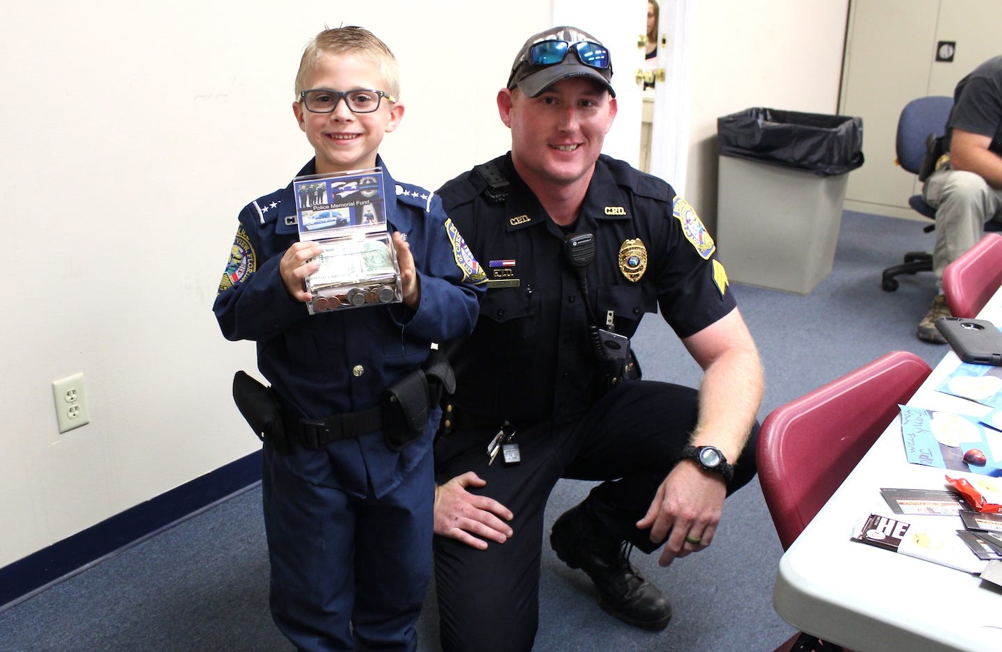 The Crestview Police Department’s unofficial “policeboy,” Jae Williams, 6, presents to Sgt. Josh Grace $331.28 he raised toward an Okaloosa County fallen law enforcement officers memorial being planned by the Crestview Citizens Police Academy Alumni association. [BRIAN HUGHES | Crestview Police Department]