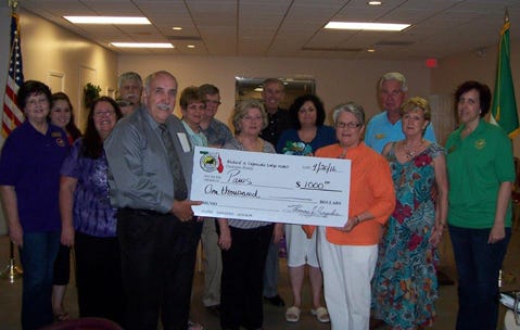 Sons of Italy in American Crestview lodge president Thomas Hughes (left, holding check) presents $1,000 to Bonnie Stine (right, holding check)of the Panhandle Animal Welfare Society, along with other lodge members recently at Foxwood County Club.
