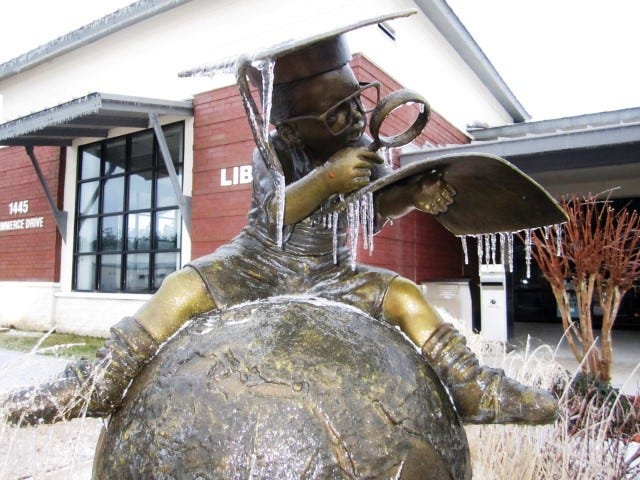 Icicles drip from "The Whiz Kid" sculpture in front of the Crestview Public Library Wednesday morning.