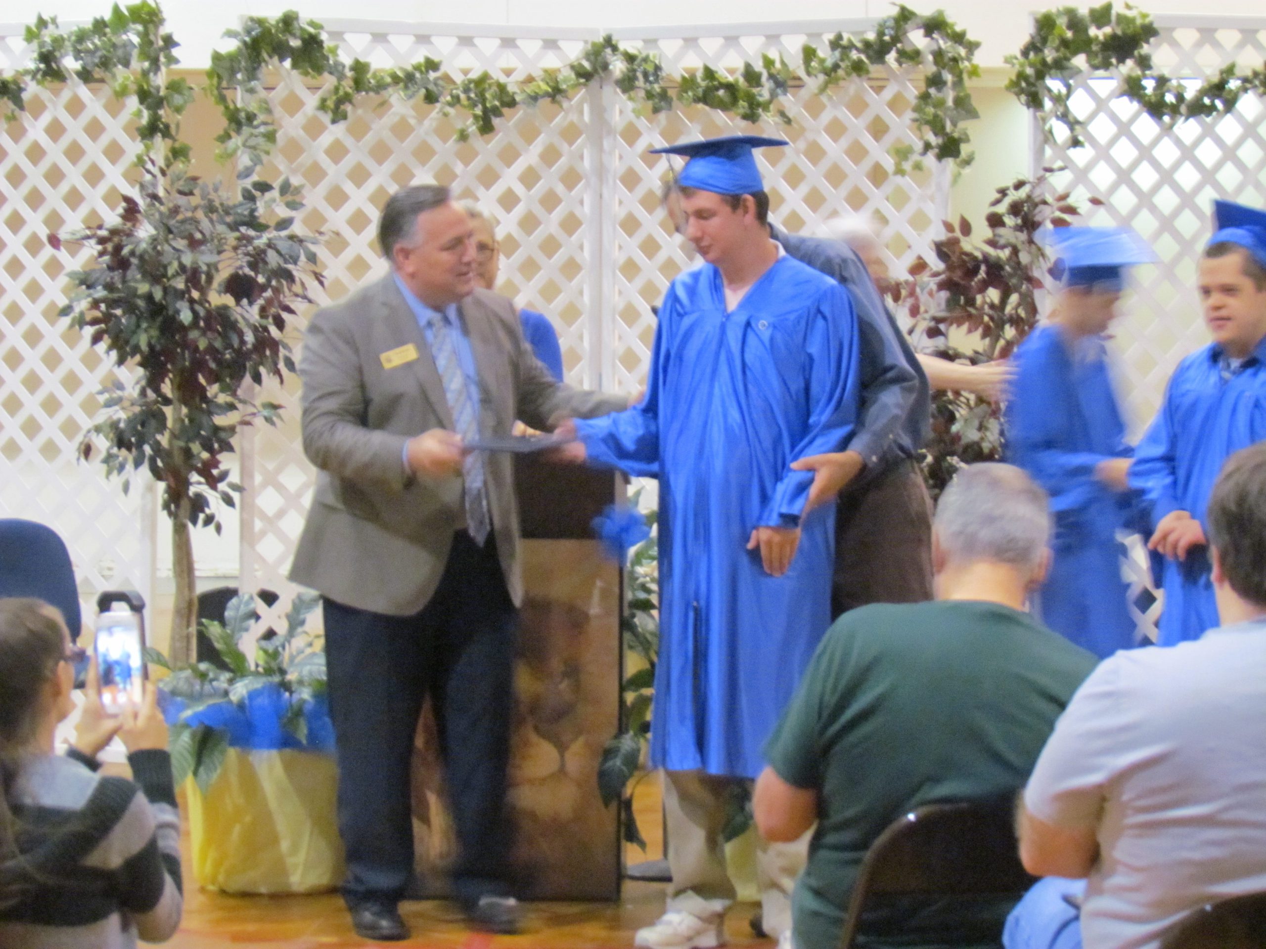 Okaloosa County School Board member Tim Bryant gives Devyn Brown his diploma at Richbourg School's graduation. [ALICIA ADAMS/NEWS BULLETIN]