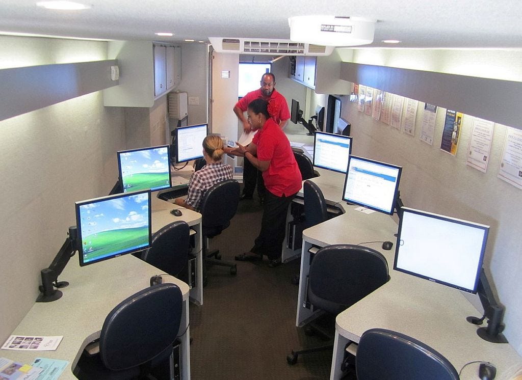employment counselors assist a resident with a job search in the CareerSource Okaloosa Walton Mobile One-Stop unit that now visits the Crestview Public Library twice a week since closure of the agency's Wilson Street office.