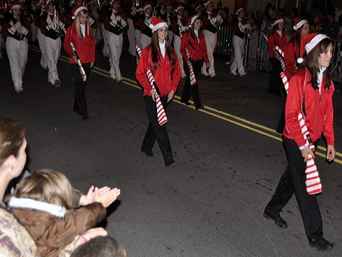 Spectators watch Crestview High School students march by during Saturday night's Christmas Parade on Main Street.
