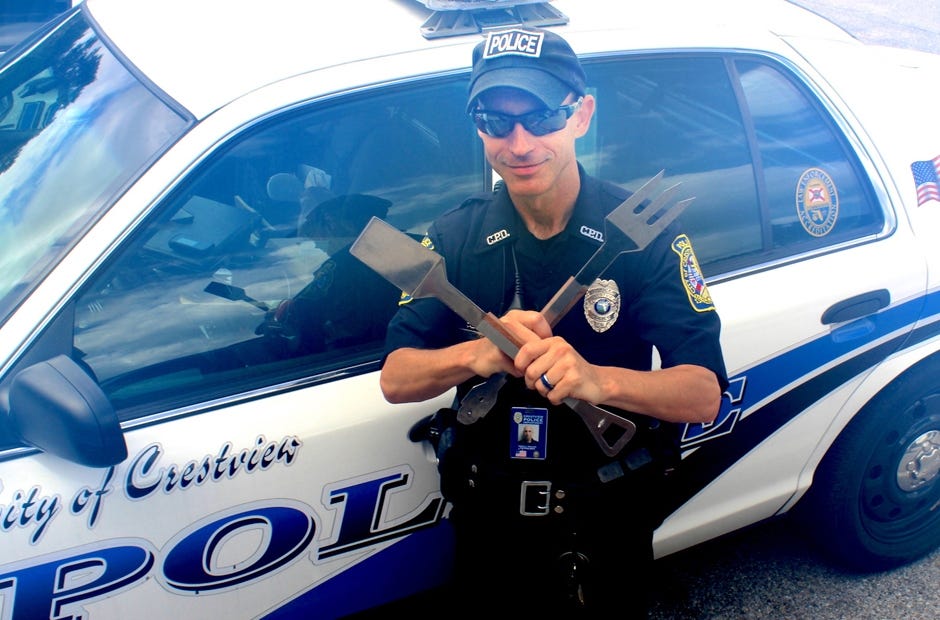 Crestview Police Officer Corey Newcomb wields his backyard barbecue tools. [Brian Hughes | Crestview Police Department]