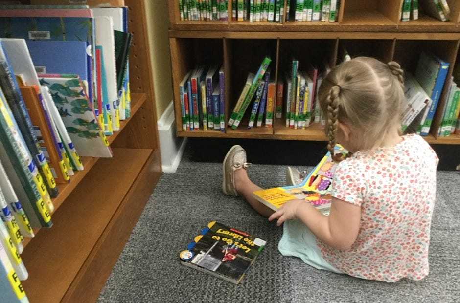 Everly Jennings looks at books during a recent visit to the Crestview Public Library. [Special to the News Bulletin]