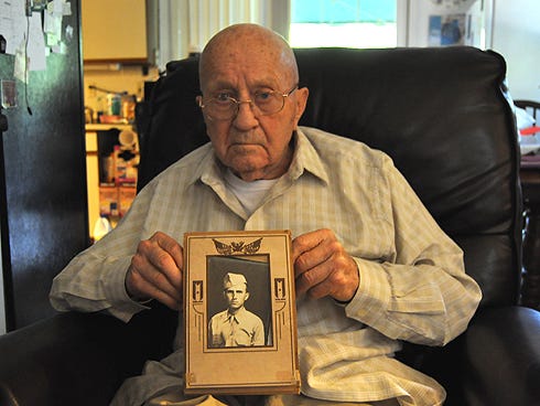 Crestview resident Harmon Ferguson, 90, holds a picture of himself, taken shortly after the U.S. Army drafted him in 1943. Ferguson, who served in the military 20 years, said he never misses a Memorial Day observance.