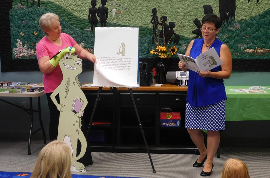 Author Angela Yuriko Smith, right, assisted by her helper, Laura Duerrwaechter, reads one of her books recently at the Niceville Public Library. Smith will present book readings at the Crestview Public Library July 11 and 12. [Karen Houston | Special to the News Bulletin]