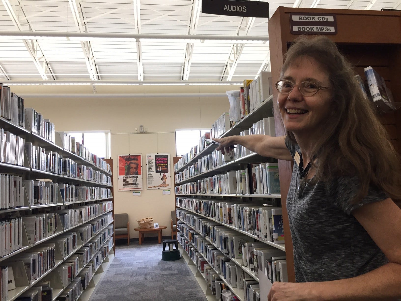 Sandra Dreaden points down an aisle of books at the library. [GENEVIEVE DiNATALE | NEWS BULLETIN]