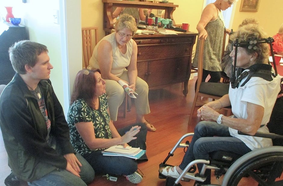 Rollin Cluff, the first recipient of the Crestview Area Sister City Programís student travel fellowship, and his mother, Debra, seated on the floor, discuss plans for Rollinís visit to Noirmoutier with program members Becky Sanderson and Corina Zolace during a lunch for program members recently in Crestview. [Brian Hughes | Special to the News Bulletin]