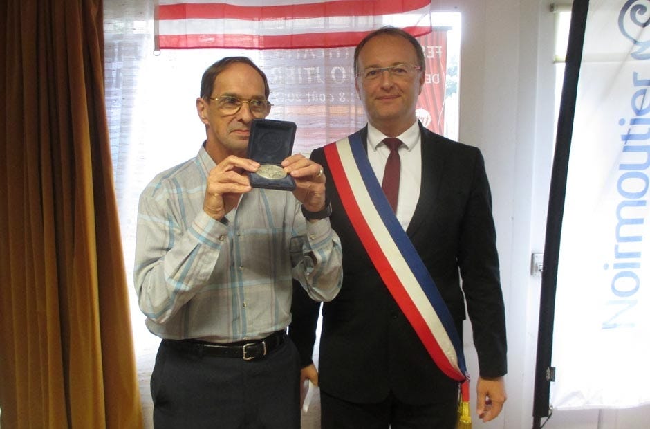 Crestview City Council President JB Whitten receives the Medal of Noirmoutier from the island community's mayor, Dr. Noel Faucher, during a reception for the visiting Crestview delegation on Sept. 9 in Noirmoutier, France. [Brian Hughes | Special to the News Bulletin]