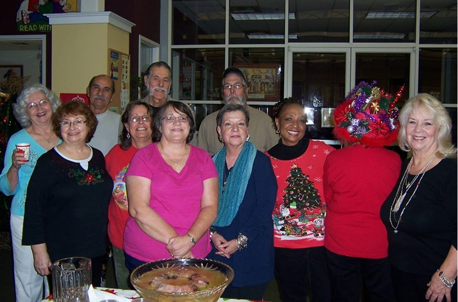Friends of the Crestview Library members enjoy one of the annual Noel Night events. Pictured are Ruby Frabott, Lucy Smith, Bonny Crews, Nancy Moxcey, Rae Schwartz, Jean Lewis, Wanda Fogle in Christmas hat (back to camera), and Lois Molina in front row; and Louie Molina, Mickey Frabott, and Steve Crews.