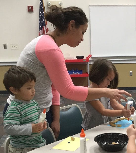 Local residents Javi, Cori and Alessandra Martinez make pasta pictures during a class Sept. 25 at the Crestview Public Library. Javi is 1 and Alessandra is 3. [Special to the News Bulletin]