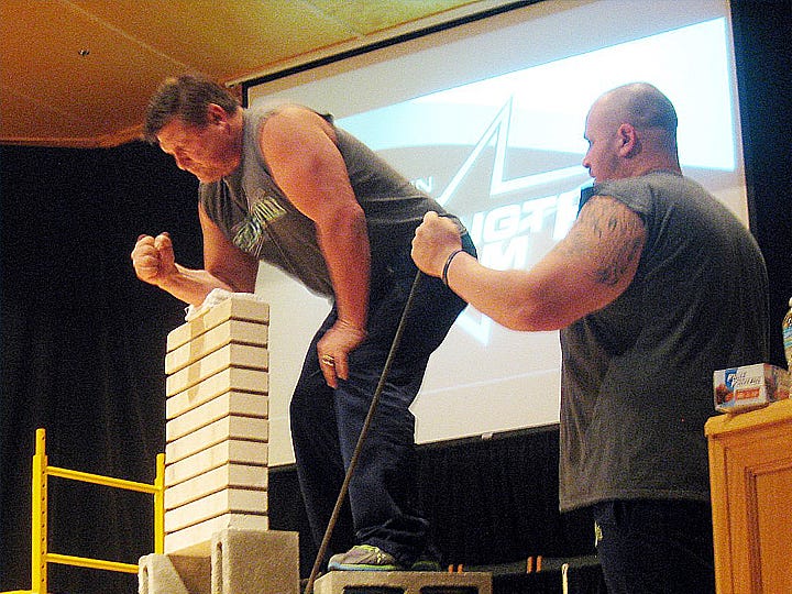 Strength Team founder and leader Mike Hagen — encouraged by member Zeb Bishop — prepares to chop through a stack of 10 bricks at Woodlawn Baptist Church.