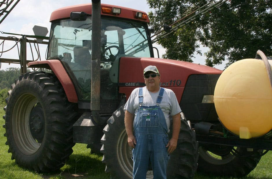Russell Boyett stands in front of his tractor on his farm. [Jennifer Bearden | Special to the News Bulletin]