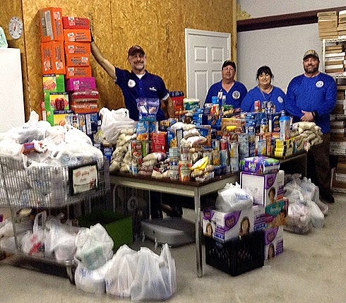 Ed Corbett, Luke Sheplock, Linda Mitchem, and Eric Marshall, members of the Crestview Citizens Police Academy Alumni Association, stand with food collected for Sharing and Caring April 1 in Crestview.